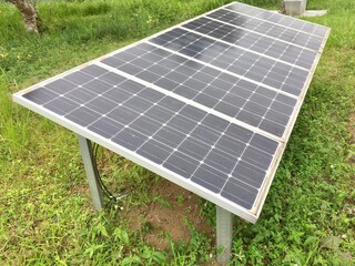 Photovoltaic solar panel on grass background, green clean alternative energy concept.