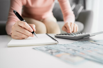 Close up of Young women or accountants using a calculator calculated and doing accounting for income and expenses, saving and planning money, dollar banknote, retirement investment concept.