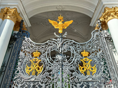 SAINT PETERSBURG, RUSSIA - August 18, 2020: The two-headed eagle and coats of arms on the metal wrought-iron patterned gates of the Winter Palace in St. Petersburg are heraldic symbols of Russia.