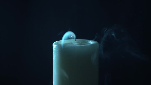 Vel&oacute;n en fondo negro, apag&aacute;ndose y dejando humo