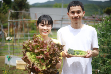 野菜を持つ夫婦