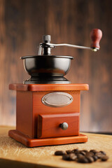 Manual coffee grinder filled with coffee beans shot over black background