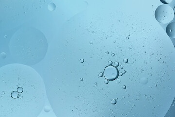 oil drop floating or Cosmetic liquid serum on the water blue bubbles background