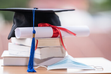 Closed-up photo of a college graduation cap mortarboard with degree diploma certificate and face...