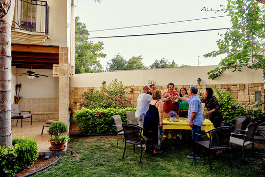 Mexican latinx multi generation group of friends and family, latino, Latina, cheering in a garden party outdoor celebration.