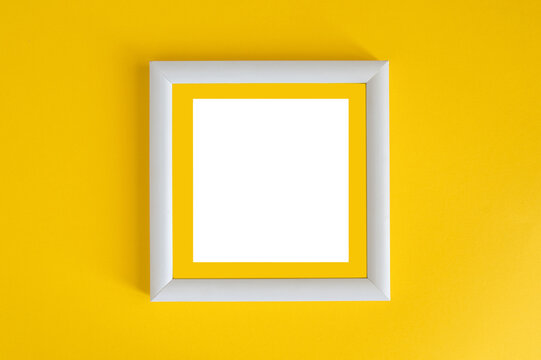 White wooden photo frame on a yellow background. Minimalism.
