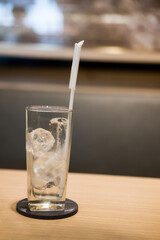 Glass with an ice cube standing on the table
