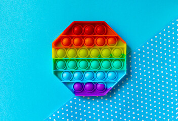 Trendy Pop it fidget toy on black background. Rainbow octagon anti stress fidget.