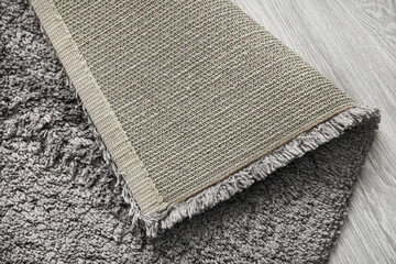 Grey carpet on wooden floor, closeup