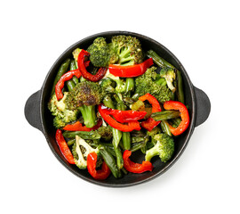 Frying pan with different vegetables on white background