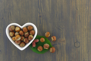 Fresh unshelled hazelnuts in a heart shaped dish