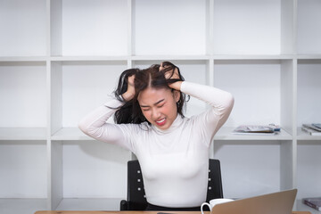 Furious and frustrated asian woman steaming and pulling her hair.