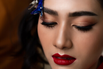 Close up beautiful young asian woman face Young lady get beautiful makeup Hairdresser doing hair style on fashion model hair before attractive fashion model girl go to work She has beautiful makeup