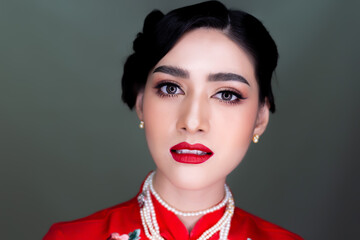 Beauty makeup and beauty face young asian woman portrait Charming beautiful girl apply red lipstick on mouth and get beauty makeup and nice hairdo Attractive female has big eyes and beauty facial skin