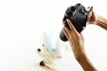 Female photographer taking picture of cosmetic products .Startups entrepreneurs small business, freelance at home office. Online marketing concept.