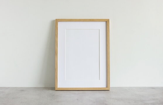 Frame mockup template on white wall  background on gray concrete desk. Copy space. Minimal concept. Interior wall accessories.