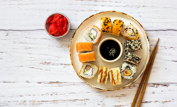 Sushi set served on grunge plate on old wooden table