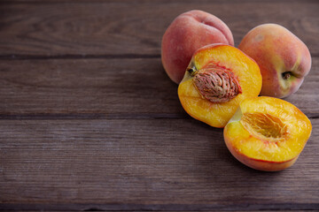 Ripe juicy peaches lie on a wooden table.