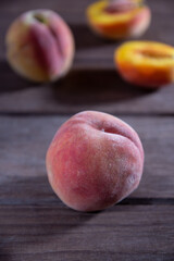 Ripe juicy peaches lie on a wooden table.