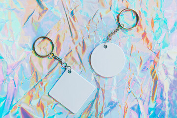 Keychain mockup on holographic background to display design. Blank rhombus white sublimation key...