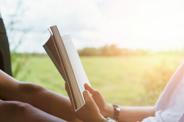 Woman is reading book in beautiful park and pond relax and peaceful environment