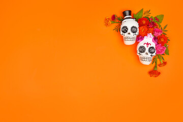 Fototapeta premium Day of the dead, Dia De Los Muertos, halloween Celebration Background. Sugar Skull, calaverita, marigolds flowers, Orange Copy Space. Traditional Mexican culture festival flyer. Flat lay, top view.