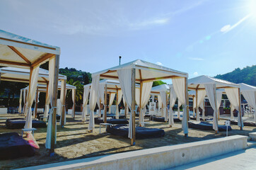 Landscape outdoor cabana bed on the sand beach in sunny day. Adriatic coast and sea in Slovenia. Holiday, wedding and celebration concept. 