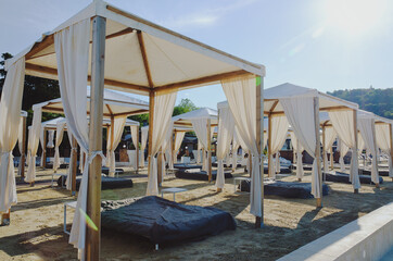 Landscape outdoor cabana bed on the sand beach in sunny day. Adriatic coast and sea in Slovenia. Holiday, wedding and celebration concept. 