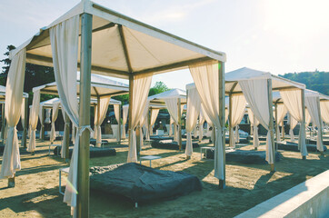 Landscape outdoor cabana bed on the sand beach in sunny day. Adriatic coast and sea in Slovenia. Holiday, wedding and celebration concept. 