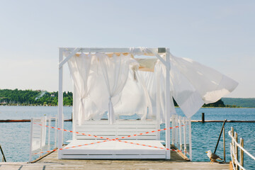 Obraz na płótnie Canvas Landscape outdoor cabana bed on the pier near beach in sunny day. Adriatic coast and sea in Slovenia. Holiday, wedding and celebration concept. 