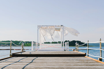 Landscape outdoor cabana bed on the pier near beach in sunny day. Adriatic coast and sea in Slovenia. Holiday, wedding and celebration concept. 