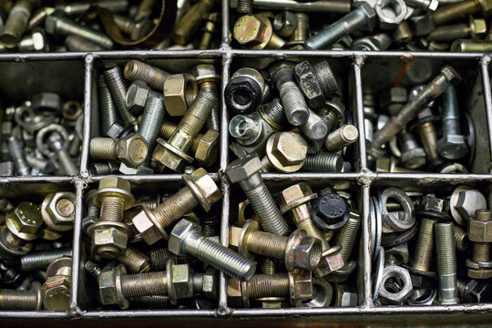 Bolts in an iron box. Screws, tools, nuts