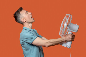Profile of man holding fan in his hands