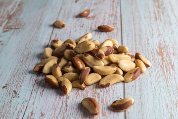 A pile of natural Brazil nuts on a wooden table, healthy fat and protein food, vegan, ketogenic nutrition concept, plant-based diet.