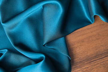 Blue silk drapery and upholstery fabric from the courtyard. Blue satin, silky fabric, wave, draperies. Beautiful textile backdrop. Close-up. Top view