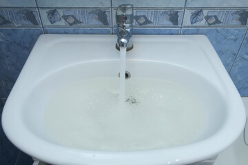 Drain hole in sink is clogged and water is collecting pouring from faucet. Water pours into a...