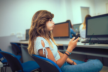 College students using phone in a computer lab