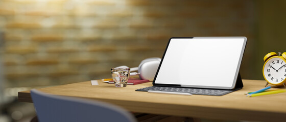 Mockup blank white screen tablet with keyboard and copy space on wooden workspace at home