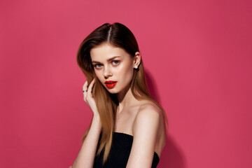 Fototapeta premium beautiful woman in a black dress pink background