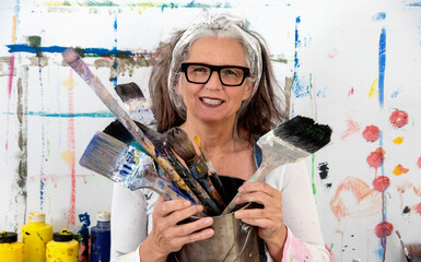 lucky, proud portrait of an older mature smiling woman, artist, in her fifties with grey hair and...