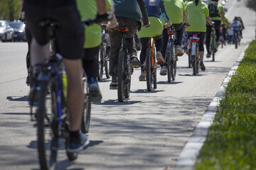 Naklejka na ściany i meble A group of bikes cyclists riding during the street. Many people racing.