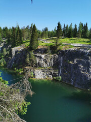 View of the picturesque rocky shores and the emerald water of the Marble Canyon in the Ruskeala Mountain Park on a sunny summer day.