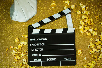 Cinema hatch with popcorn, Covid test and mask, on golden background - obrazy, fototapety, plakaty