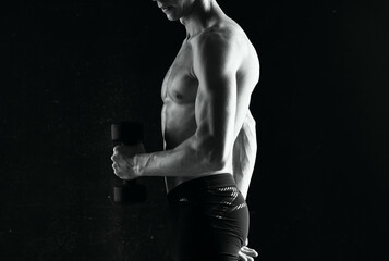 Fototapeta na wymiar man with dumbbells in hands pumping up muscles exercises