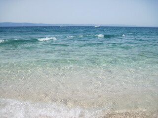 Scenic shining view of the clear water of Adriatic Sea on a sunny summer day. Colorful natural fresh background for creative illustration with shiny blur effect. Bright nautical scape beauty closeup