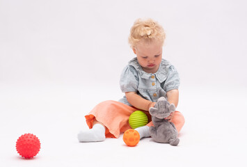 Pretty  baby girl plays with colorful balls
