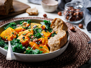 Season salad with grilled pumpkin, kale, chickpea, pepitas and nuts. Autumn vegetarian healthy recipe.