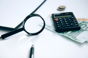 Calculator, paper money, a stack of coins and a folder with documents isolated on white background....