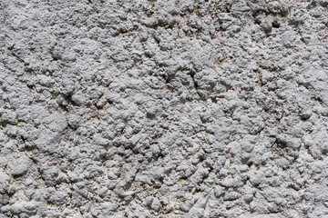Close-up of decorative wall plaster. Abstract gray texture. Contrasting shadows on a bright sunny day