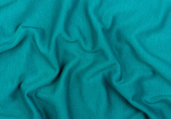 Fototapeta premium Turquoise jersey fabric matte texture top view. Blue knitwear background. Fashion color trendy clothes. Website backdrop